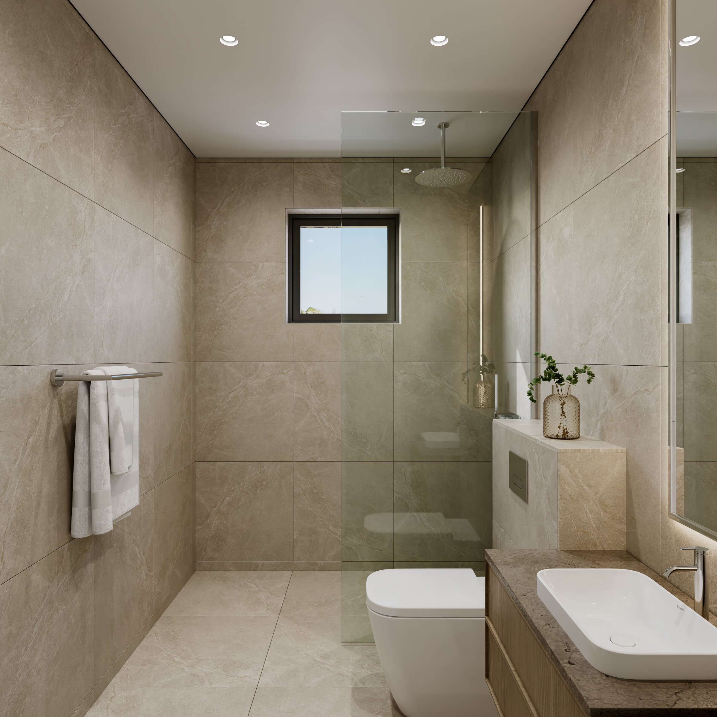 En-suite bathroom finished in stone with European sanitary ware.